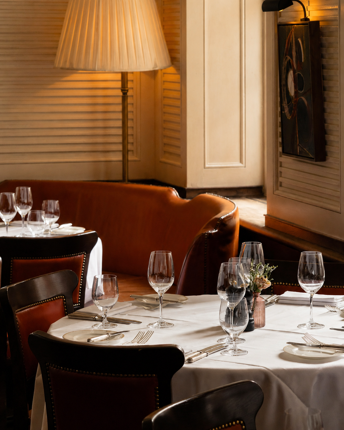 The dining room at 34 Mayfair at lunch: a standing lamp, cognac leather and white linen