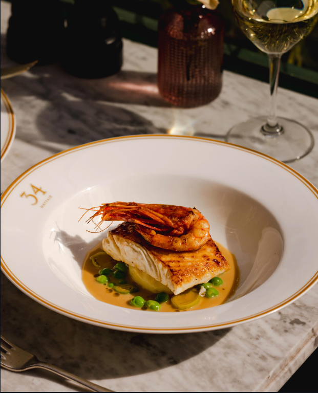 Halibut with prawn and summer peas, served on marble in terrace light