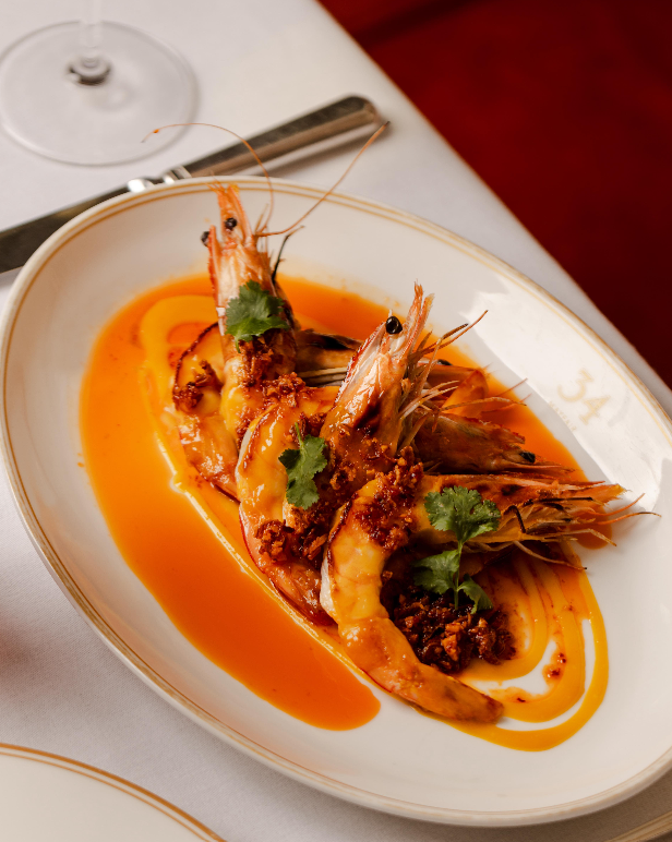Grilled king prawns with garlic and chilli on a gold-rimmed platter