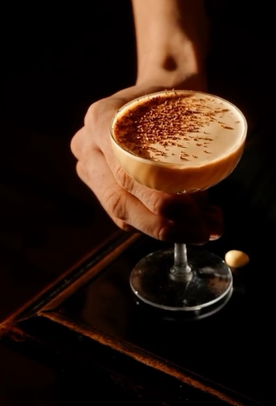An espresso martini held up to the light at the bar